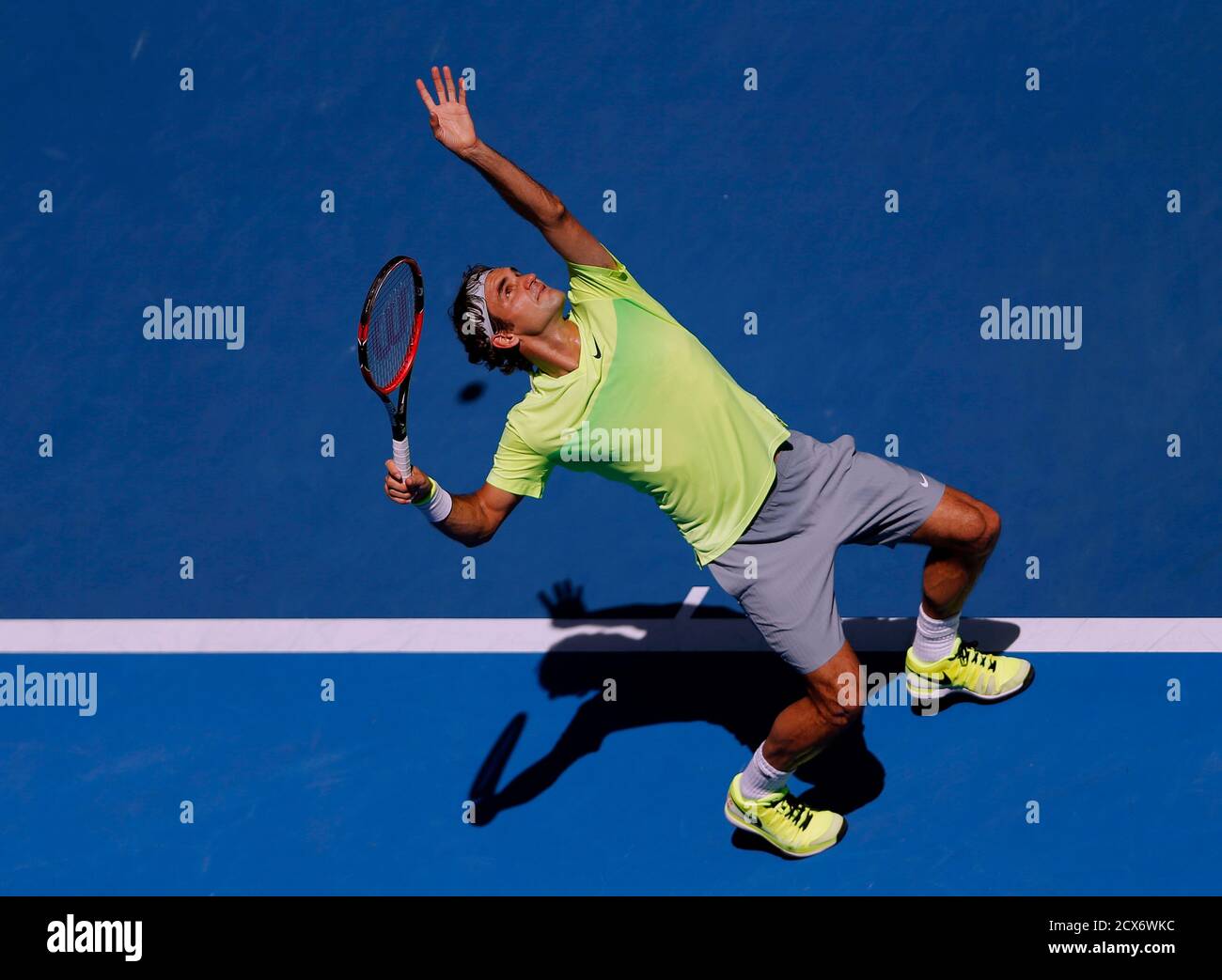 Roger Federer of Switzerland casts a shadow as he serves to Andreas Seppi  of Italy during their men's singles third round match at the Australian  Open 2015 tennis tournament in Melbourne January