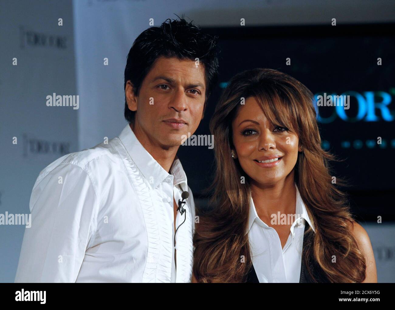 Bollywood actor Shah Rukh Khan (L) and his wife Gauri pose for a picture after a news conference in Mumbai August 26, 2010. One of India's most popular superstars, Khan, 44, is known for guarding his personal life fiercely from the media glare. But for a change he has allowed a bit of the spotlight into his home, appearing in an ad campaign for a furnishing brand with his wife, their first endorsement together. Picture taken August 26, 2010. To match Reuters Life! INDIA-SHAHRUKH/  REUTERS/Danish Siddiqui (INDIA - Tags: ENTERTAINMENT PROFILE) Stock Photo