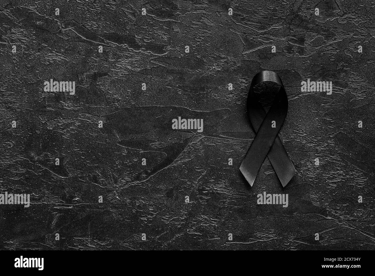 Black awareness ribbon on dark background. Mourning symbol Stock Photo