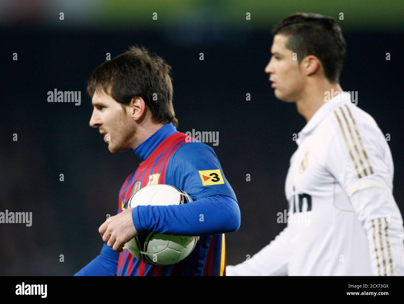 Barcelona's Lionel Messi (L) holds the ball besides Real Madrid's Cristiano  Ronaldo during their Spanish King's Cup quarter-final second leg 