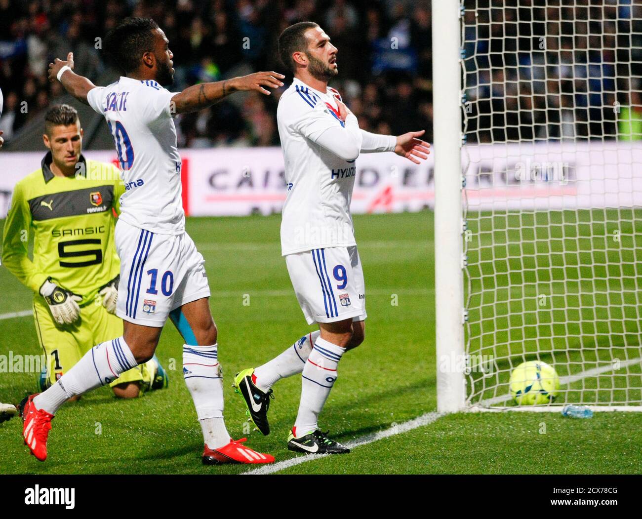 Olympique Lyon's Lisandro Lopez (R) celebrates his goal with team mate  Alexandre Lacazette (C) against Stade Rennais's goal keeper Benoit Costil  (L) during their French Ligue 1 soccer match at the Stade