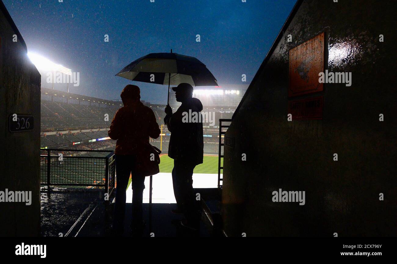 Dean Jean-Pierre (R) and Dewanna Planter from Largo, Maryland brave a  rainstorm to find covered seats in the upper deck before the Baltimore  Orioles and New York Yankees take to the field