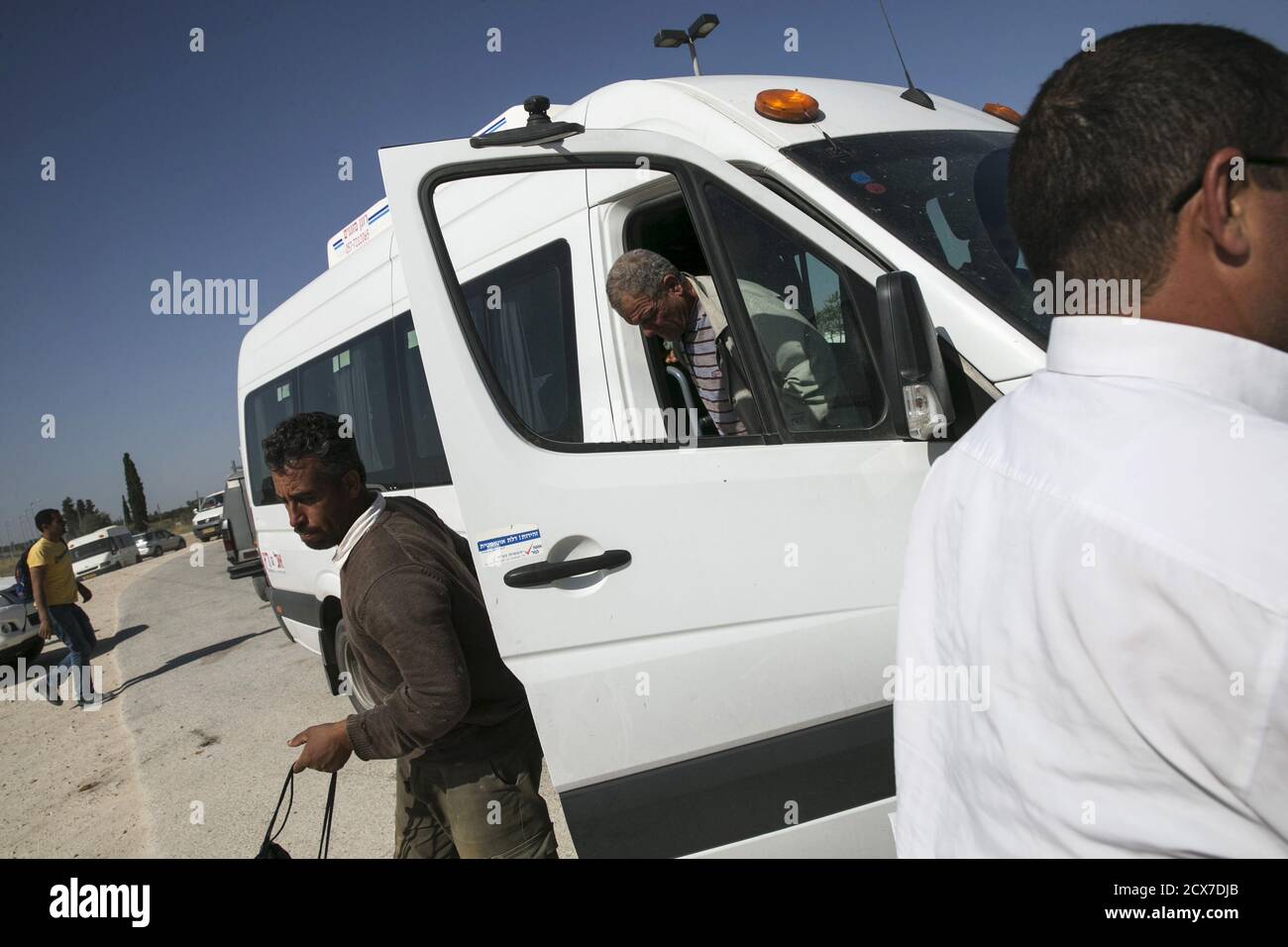 Palestinian labourers with permits to work in Israel step off a minibus as they return to the West Bank at Israel's Eyal checkpoint near the West Bank town of Qalqilya May 20, 2015. Prime Minister Benjamin Netanyahu suspended on Wednesday new bus travel and checkpoint regulations for Palestinian labourers only hours after they were imposed to an outcry by critics accusing Israel of racial segregation. REUTERS/Baz Ratner Stock Photo