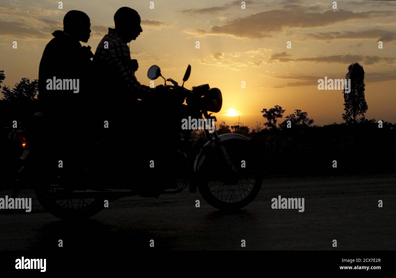 A motorbike taxi carries a passenger at sunset in the U.S. President Barack Obama's ancestral village of Nyang'oma Kogelo, west of Kenya's capital Nairobi, July 15, 2015. President Obama visits Kenya and Ethiopia in July, his third major trip to Sub-Saharan Africa after travelling to Ghana in 2009 and to Tanzania, Senegal and South Africa in 2011. He has also visited Egypt, in North Africa, and South Africa for Nelson Mandela's funeral. Obama will be welcomed by a continent that had expected closer attention from a man they claim as their son, a sentiment felt acutely in the Kenyan village whe Stock Photo
