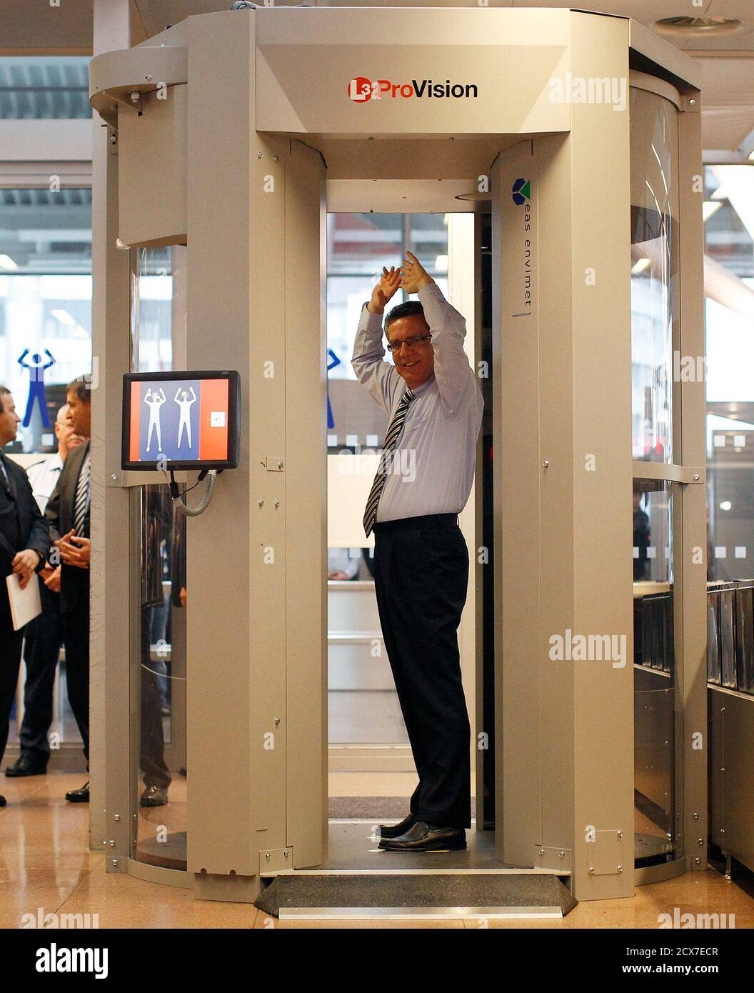 Germany's Interior Minister Thomas de Maiziere goes through a full body  scanner during a photocall at Departure Gate 2 at Hamburg Airport September  27, 2010. Germany started on Monday the voluntary use