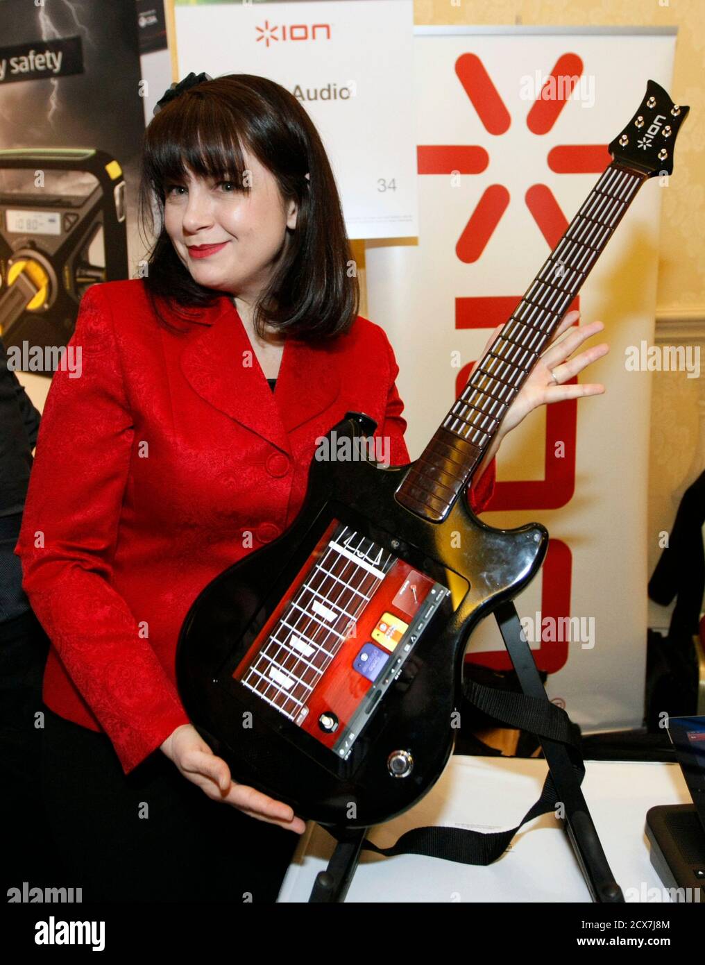 Wendy Mittelstadt, product manager for Ion, poses with the company's Guitar  Apprentice guitar controller for the iPad at the Consumer Electronics Show  (CES) opening event in Las Vegas January 8, 2012. The