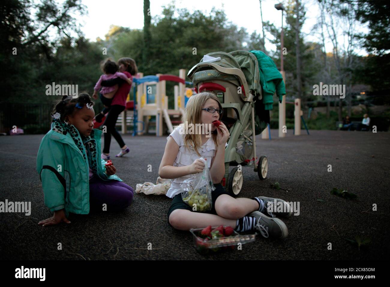 Lindzy Earp (R), 10, sits in the playground with Deja Mass, 5, at Hope Gardens Family Center, a homeless shelter for women and children, run by Union Rescue Mission on 77 acres (0.31 square km) of countryside away from Skid Row, on the outskirts of Los Angeles, California January 25, 2012. One in 45 children, totalling 1.6 million, is homeless, the highest number in United States' history, according to a 2011 study by the National Center on Family Homelessness. California is ranked the fifth highest state in the nation for its percentage of homeless children. Picture taken January 25, 2012.    Stock Photo