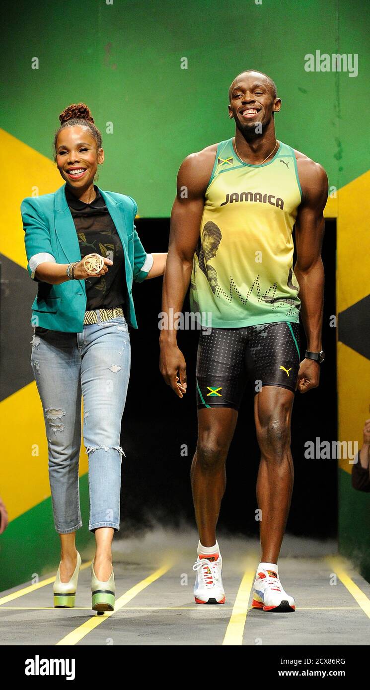Jamaican sprinter Usain Bolt models the Jamaican team's kit for the London  2012 Olympic Games, designed by Cedella Marley (L), at a fashion show in  London June 1, 2012. REUTERS/Paul Hackett (BRITAIN -