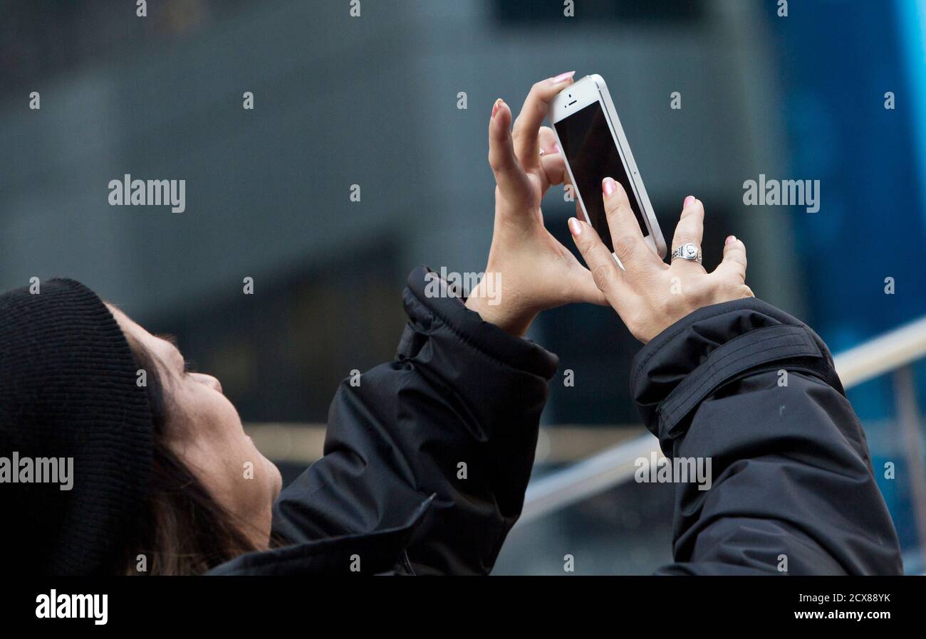 A woman takes a picture with her phone in Times Square in New York,  December 18, 2012. Instagram released an updated version of its privacy  policy and terms of service, which will