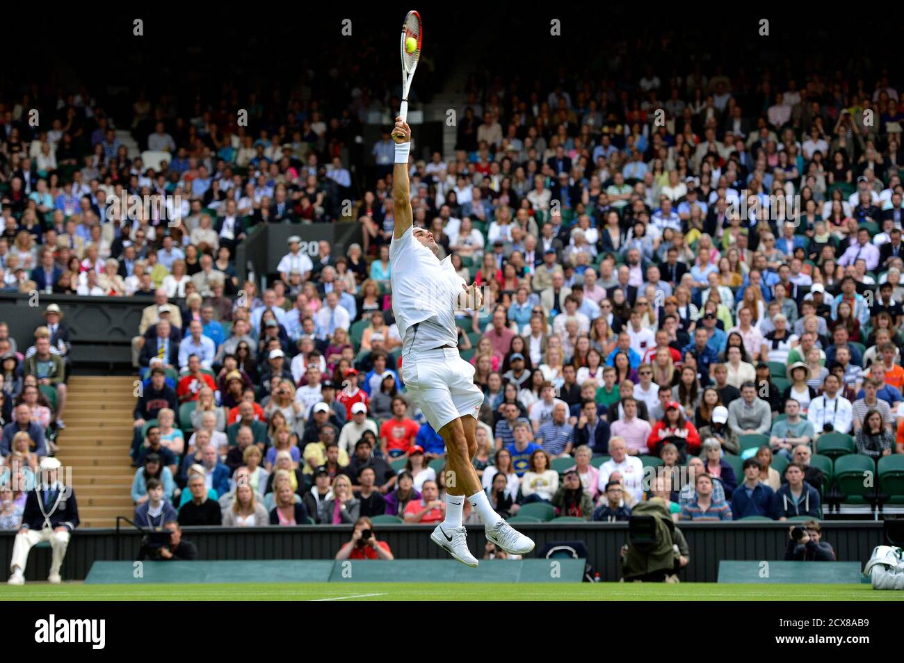 Roger Federer of Switzerland hits an overhead smash to Sergiy Stakhovsky of  Ukraine in their men's singles tennis match at the Wimbledon Tennis  Championships, in London June 26, 2013. REUTERS/Toby Melville (BRITAIN -