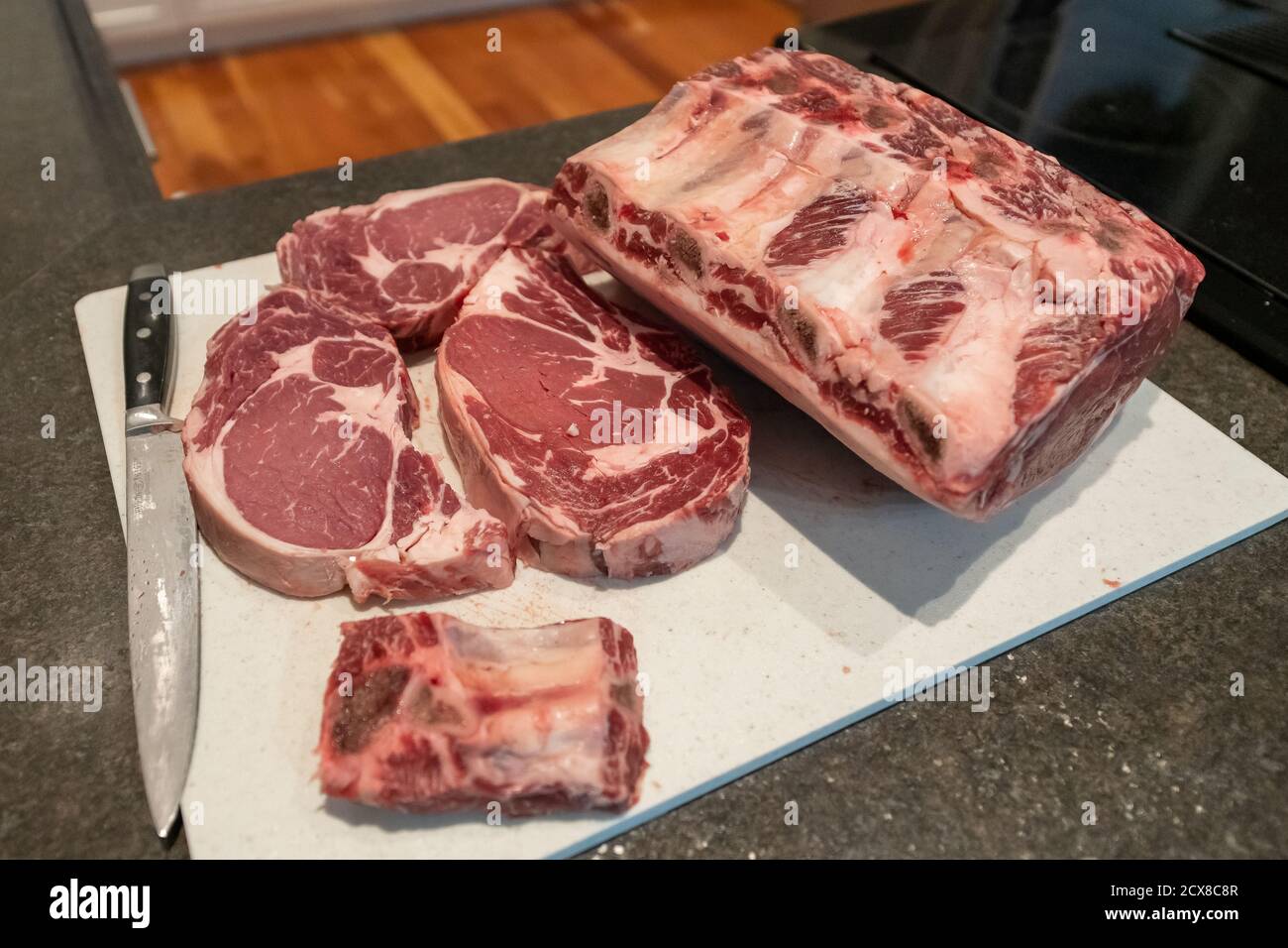 Raw beef prime rib roasts, steaks and ribs with thick pieces of meat, the marbling of fat and rib bones. Stock Photo