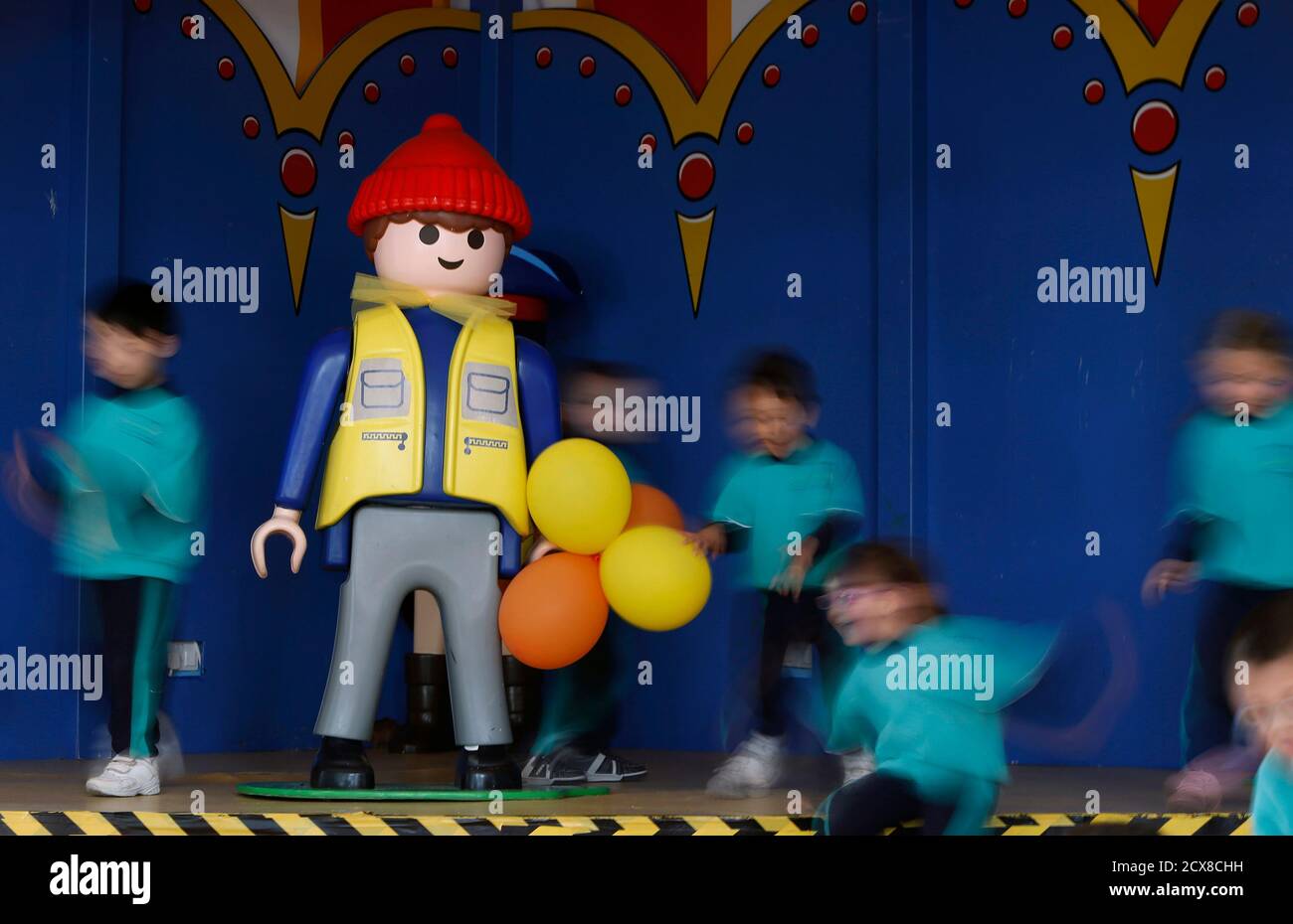 Schoolchildren play near a large Playmobil figure at the Playmobil FunPark,  adjacent to the Playmobil Malta factory in the Hal Far Industrial Estate  outside Valletta April 14, 2014. Playmobil is celebrating its