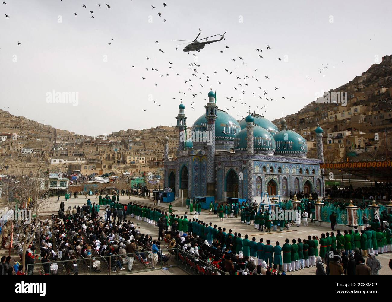 An Afghan police helicopter flies over Hazrat Ali (Kart-i-Sakhi) shrine where Afghans celebrate the Afghan New Year (Nawroz) in Kabul March 20, 2012. Afghanistan uses the Persian calendar which runs from the vernal equinox. The calendar takes as its start date the time when the Prophet Mohammad moved from Mecca to Medina in 621 AD. The current Persian year is 1391. REUTERS/Omar Sobhani (AFGHANISTAN - Tags: SOCIETY TPX IMAGES OF THE DAY)   FOR BEST QUALITY IMAGE: ALSO SEE GF2E8B30FZF01. Stock Photo