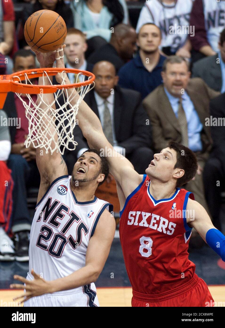 New Jersey Nets forward Jordan Williams (20) tries a layup past  Philadelphia 76ers center Nikola Vucevic (8) in the first quarter of their  NBA basketball game in Newark, New Jersey, April 23,