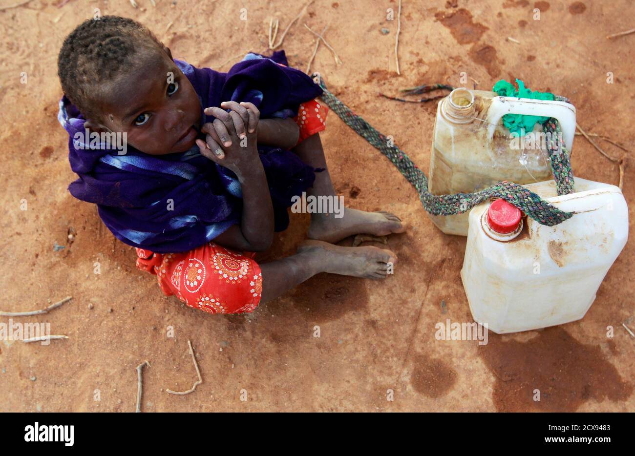 A Somali refugee girl waits for her turn to collect water from a tank at the Ifo extension refugee camp in Dadaab, near the Kenya-Somalia border, July 31, 2011. The whole of drought- and conflict-wracked southern Somalia is heading into famine as the Horn of Africa food crisis deepens, the United Nations said. REUTERS/Thomas Mukoya (KENYA - Tags: SOCIETY CIVIL UNREST DISASTER ENVIRONMENT) Stock Photo