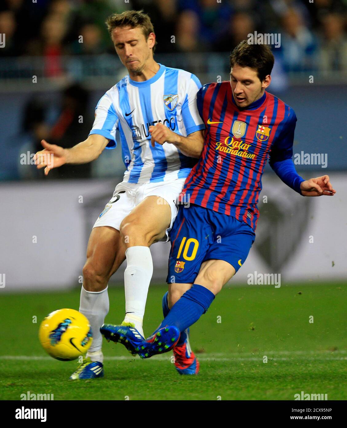 Barcelona S Lionel Messi R Kicks The Ball To Score Next To Malaga S Nacho Monreal During Their Spanish First Division Soccer Match At La Rosaleda Stadium In Malaga January 22 12 Reuters Marcelo Del