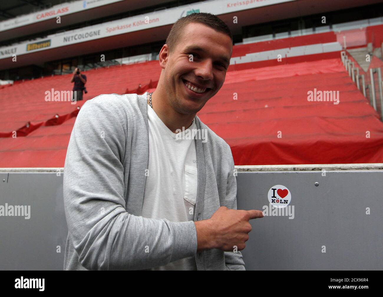 Cologne's Lukas Podolski poses next to a sticker 'I love Cologne' after a news conference in Cologne May 2, 2012. Cologne and Germany winger Lukas Podolski will join Arsenal for next season, the Bundesliga club said on Monday.  Podolski had a year left on his Cologne contract. REUTERS/Ina Fassbender (GERMANY - Tags: SPORT SOCCER) Stock Photo