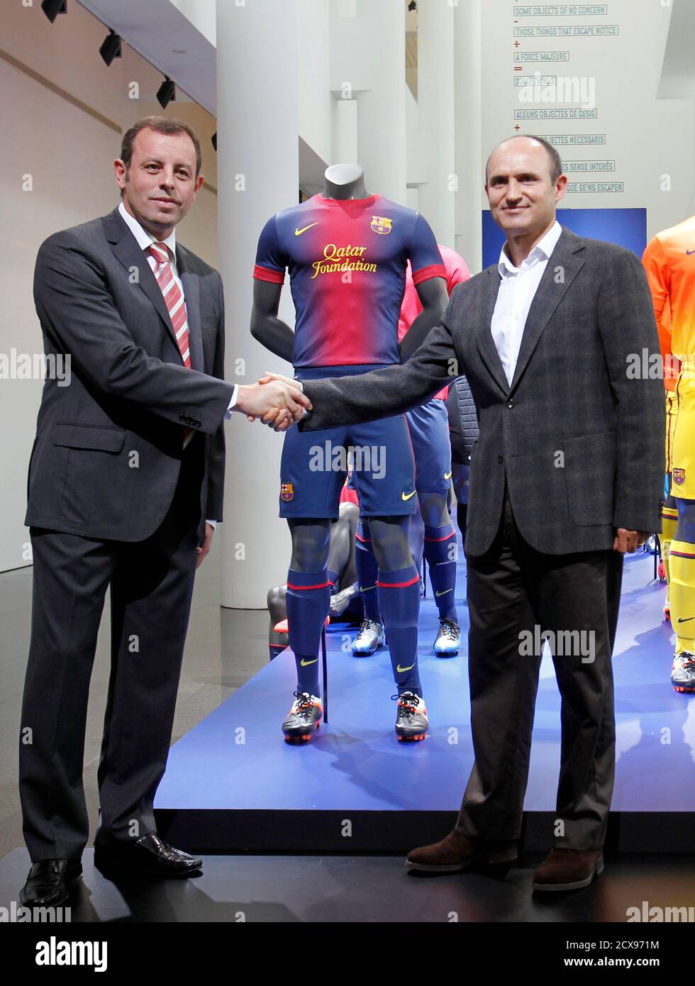 Barcelona's President Sandro Rosell (L) and Nike's Iberia President Marcos  Garzo pose with the new FC Barcelona jerseys for the 2012-2013 season  during a presentation at MACBA Museum in Barcelona May 22,
