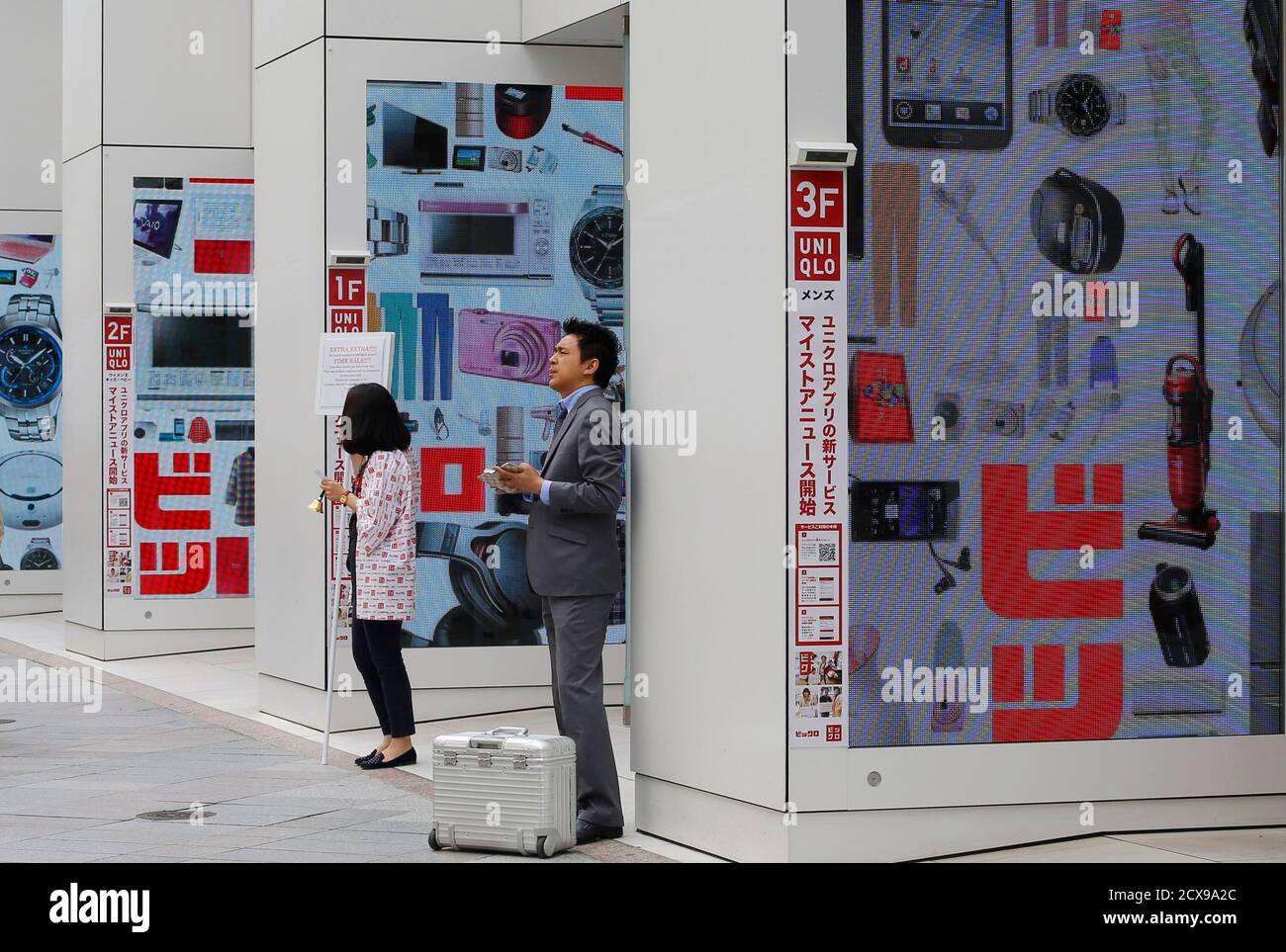 People Stand Outside A Clothing And Electronics Retail Store In Tokyo April 25 13 The Bank