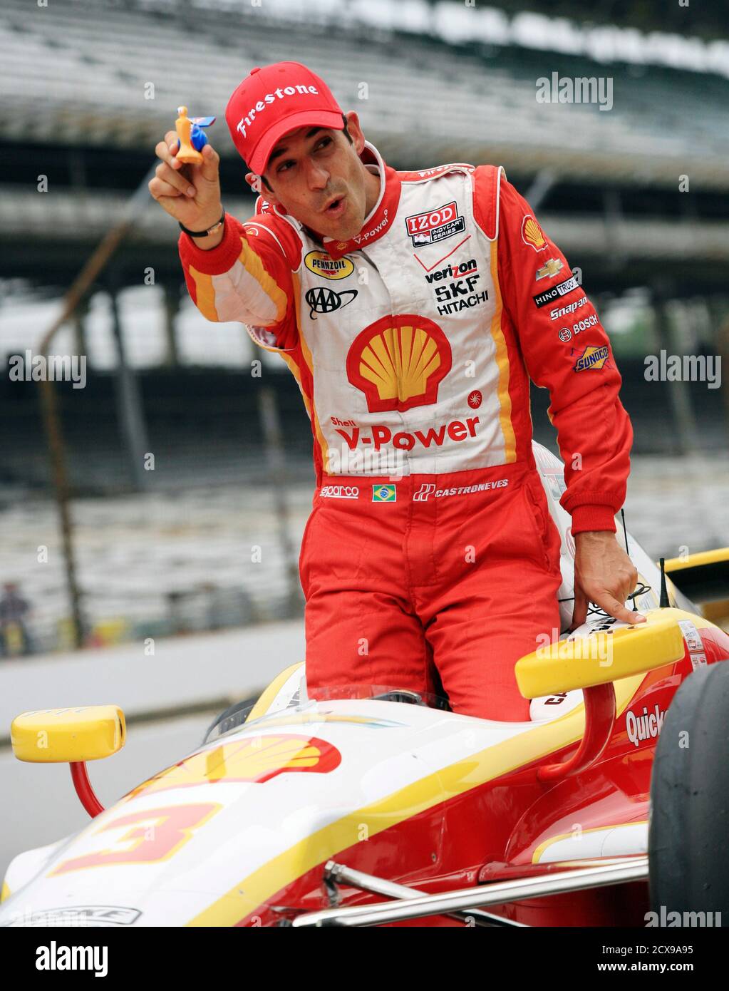 Team Penske Driver Helio Castroneves Of Brazil Holds Up A Plastic Toy