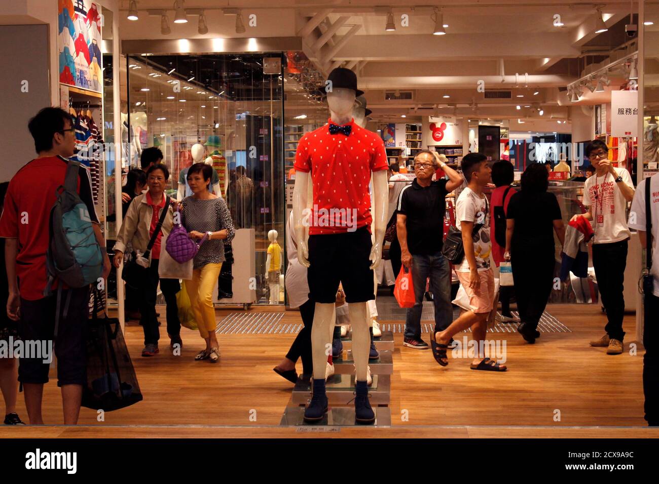 Shoppers walk inside flagship store of Japanese fashion house Uniqlo at  Hong Kong's Causeway Bay shopping district May 9, 2013. Armed with empty  suitcases and same-day return tickets, an army of mainland