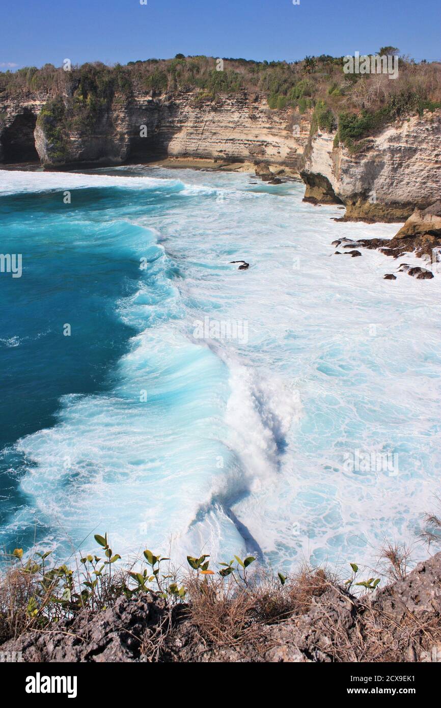 Waves crashing in turquoise blue ocean water in Nusa Penida, Indonesia Stock Photo