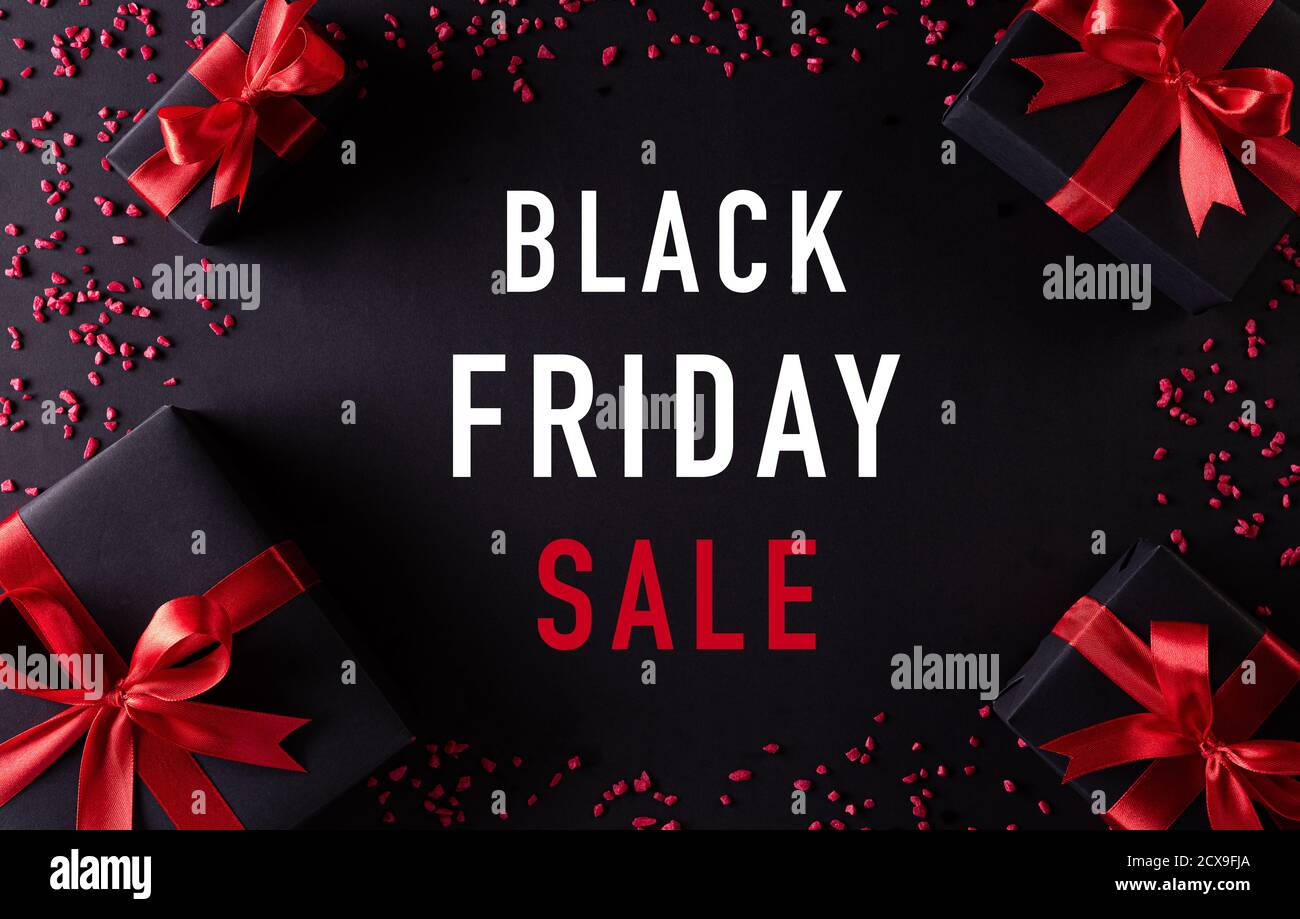 Top view of black christmas gift boxes with red ribbon on black