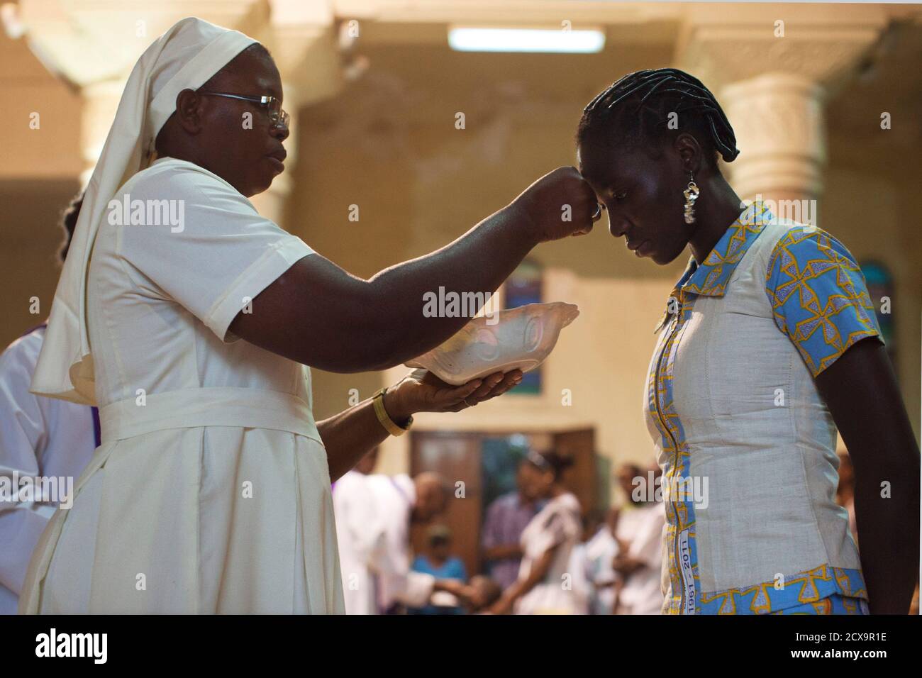 A nun marks a Catholic with ashes during Ash Wednesday mass ...