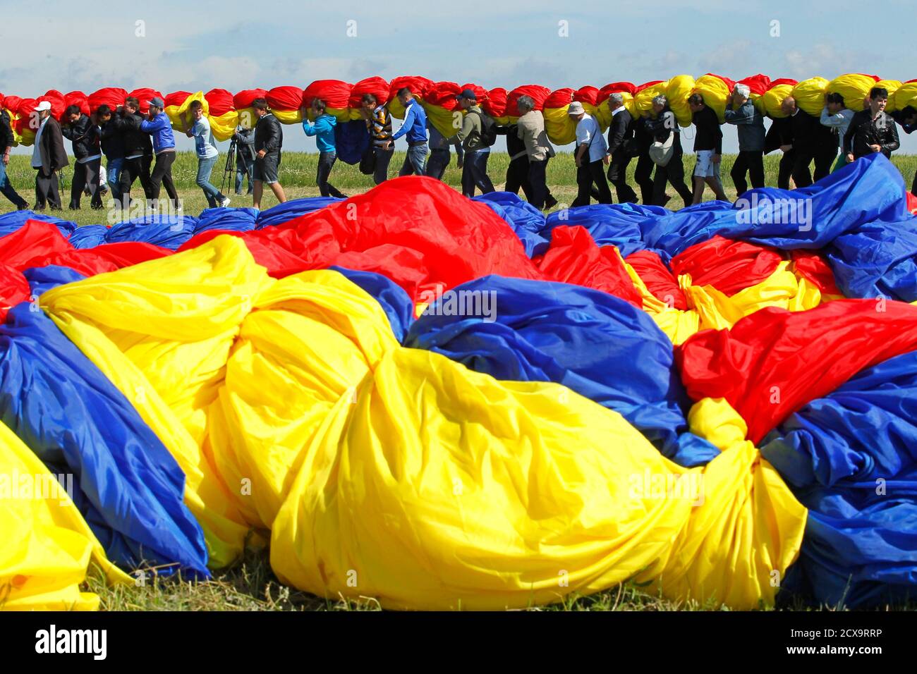 Workers carry Romania's national flag during a Guinness World Record  attempt for the world's biggest national flag in Clinceni, near Bucharest  May 27, 2013. The flag, measuring 349.4 by 226.9 meters, established