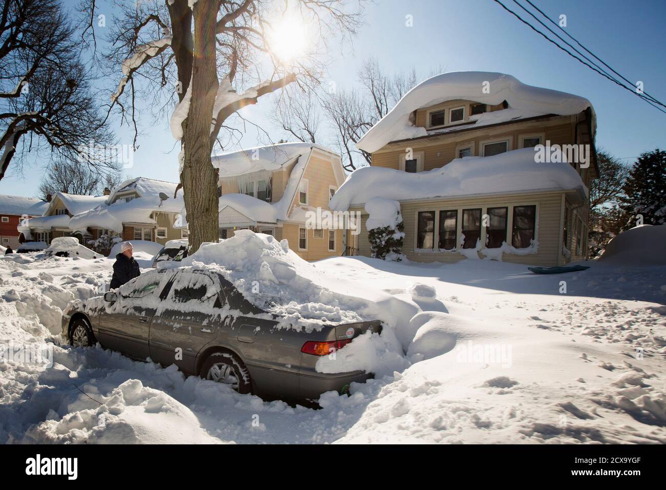 A man digs out his snow-covered car in Buffalo, New York, November 2014. Warm temperatures and rain were forecast for the weekend in the city of Buffalo and western New York,