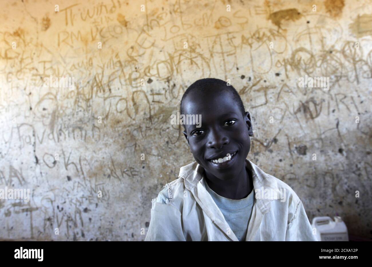 A pupil smiles as he attends a class session at the Senator Obama primary school in the U.S. President Barack Obama's ancestral village of Nyang'oma Kogelo, west of Kenya's capital Nairobi, July 16, 2015. President Obama visits Kenya and Ethiopia in July, his third major trip to Sub-Saharan Africa after travelling to Ghana in 2009 and to Tanzania, Senegal and South Africa in 2011. He has also visited Egypt, in North Africa, and South Africa for Nelson Mandela's funeral. Obama will be welcomed by a continent that had expected closer attention from a man they claim as their son, a sentiment felt Stock Photo