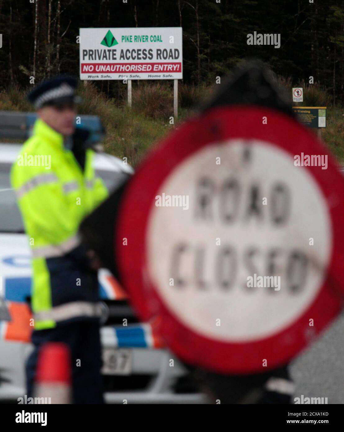 A New Zealand policeman stands at a road block on the road leading to the Pike River coal mine November 20, 2010, where 29 miners are trapped following an underground explosion on Friday. New Zealand rescuers have yet to make contact with the trapped miners as fears of lethal gas levels prevented any chance of a rescue on Saturday, 24 hours after the explosion ripped through the remote colliery dug into the side of a mountain.          REUTERS/Tim Wimborne    (NEW ZEALAND - Tags: DISASTER) Stock Photo