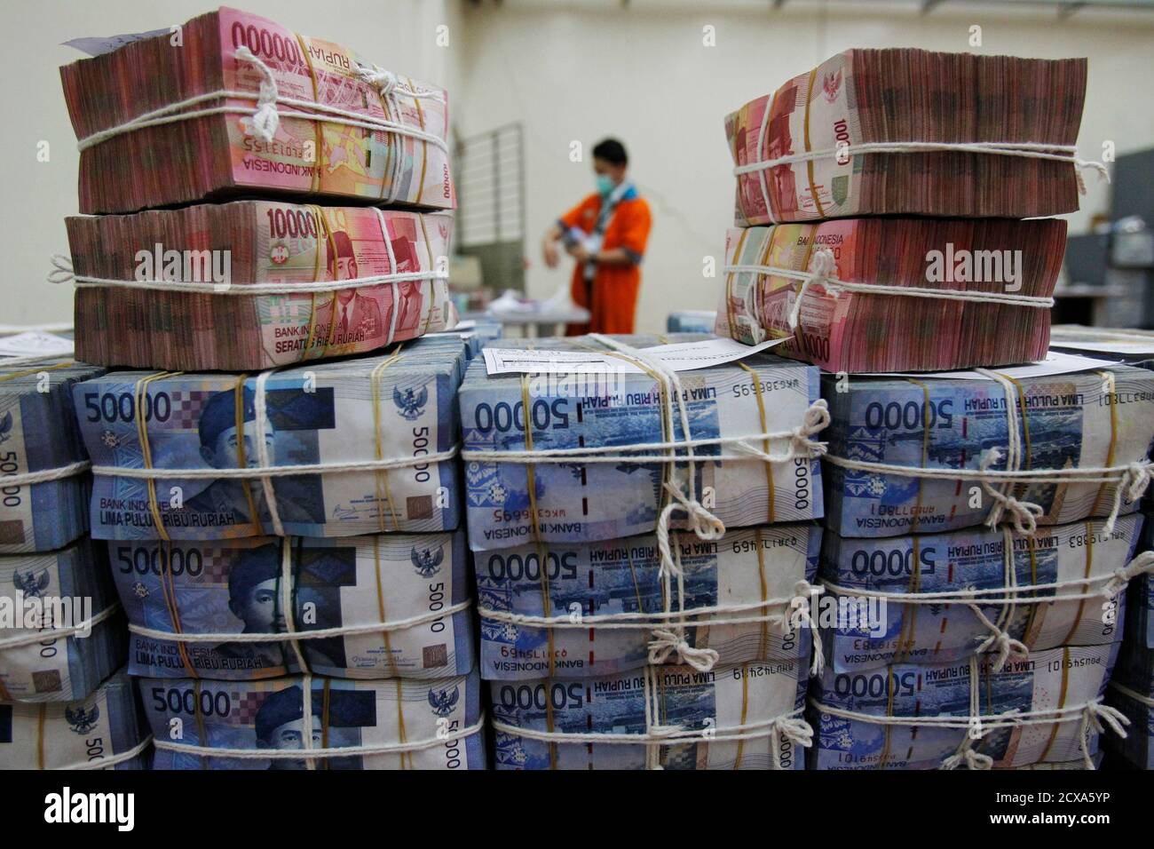 A bank employee sorts rupiah banknotes at the Bank National ...