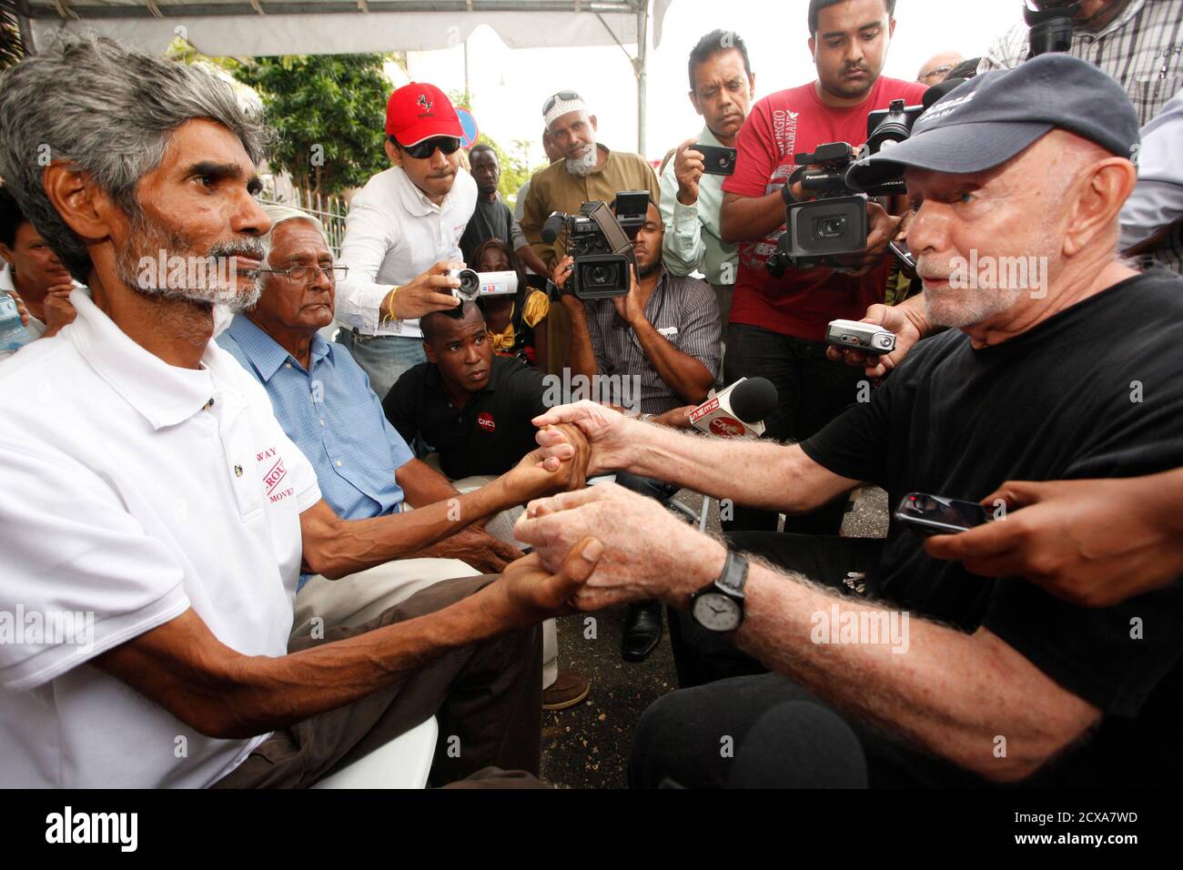 Highway Re-route Movement leader Wayne Kublalsingh (L) is greeted by Carnival costume designer Peter Minshall on the 16th day of Kublalsingh's hunger strike outside the prime minister's office in St. Clair, Port-of-Spain, November 30, 2012. The Highway Re-route Movement is demanding that the government re-route the construction of a new highway from San Fernando to Point Fortin in southern Trinidad, which the group says will displace more than 300 families and have a negative environmental impact on the Oropouche Lagoon. REUTERS/Andrea De Silva (TRINIDAD AND TOBAGO - Tags: POLITICS BUSINESS EM Stock Photo