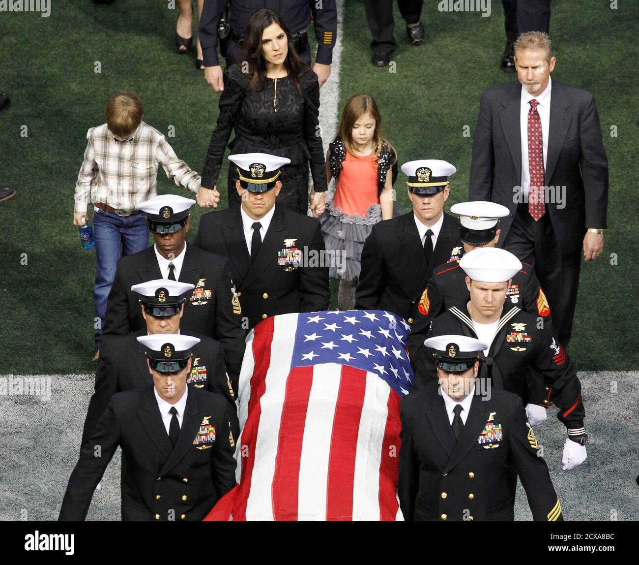 Taya Kyle (rear) and her children walk behind the coffin of her slain  husband former Navy SEAL Chris Kyle during a memorial service for the  former sniper at Cowboys Stadium in Arlington,