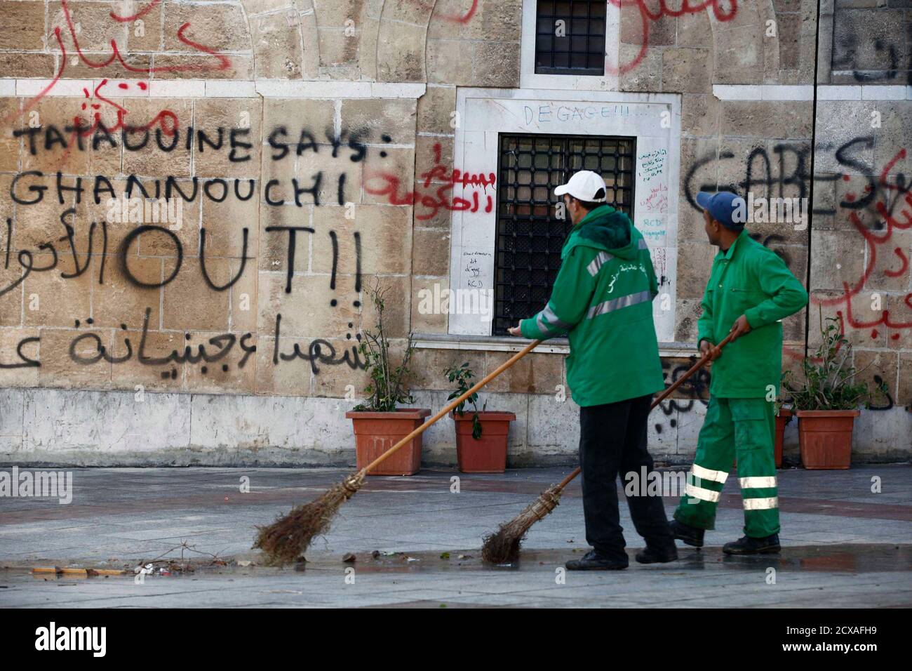 Sanitary service workers clean a street in the Kasbah district after  Tunisian inhabitants of Sidi Bouzid along with protesters were evacuated  following clashes with security forces in front of the government palace