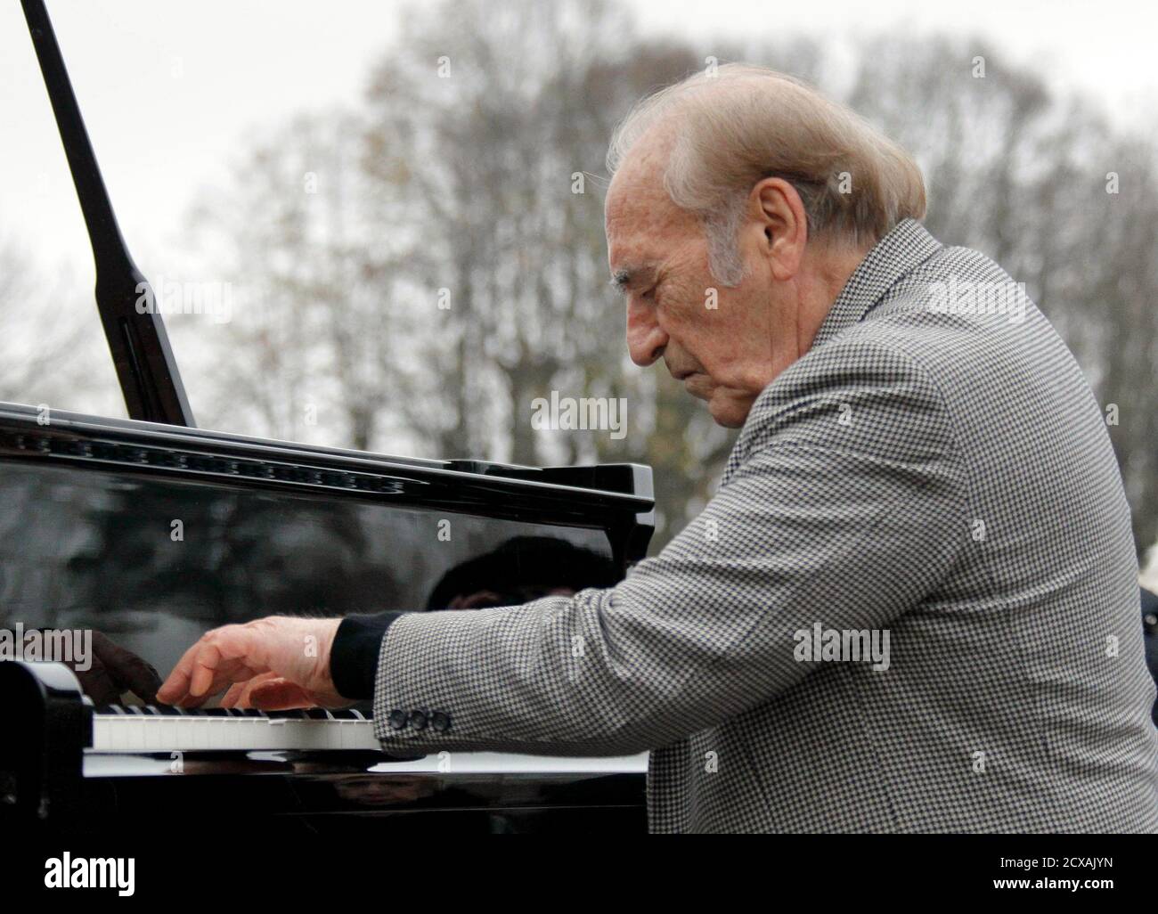 Argentine pianist Miguel Angel Estrella plays at the funeral ceremony of  Danielle Mitterrand, the widow of former French President Francois  Mitterrand, in Cluny, central France, November 26, 2011. REUTERS/Robert  Pratta (FRANCE -