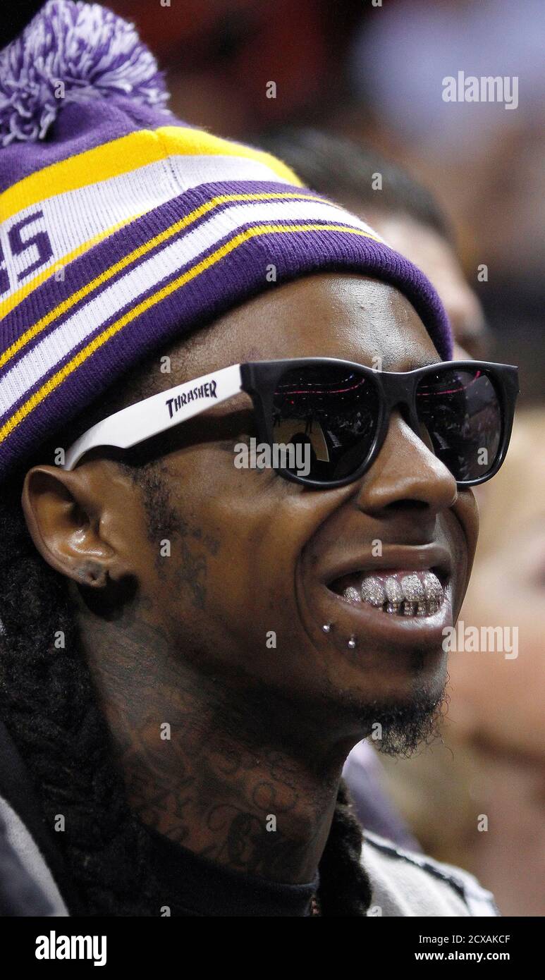 Rapper Lil Wayne smiles courtside as the Miami Heat played the Los Angeles  Lakers in an NBA basketball game in Miami, Florida January 19, 2012.  REUTERS/Andrew Innerarity (UNITED STATES - Tags: SPORT