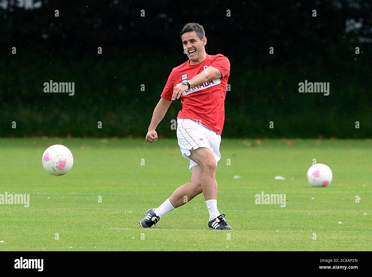 Canada's women football coach John Herdman kicks the ball during a training  session at the London 2012 Olympic Games at the Grammer School Manchester,  northern England August 5, 2012. Canada will play