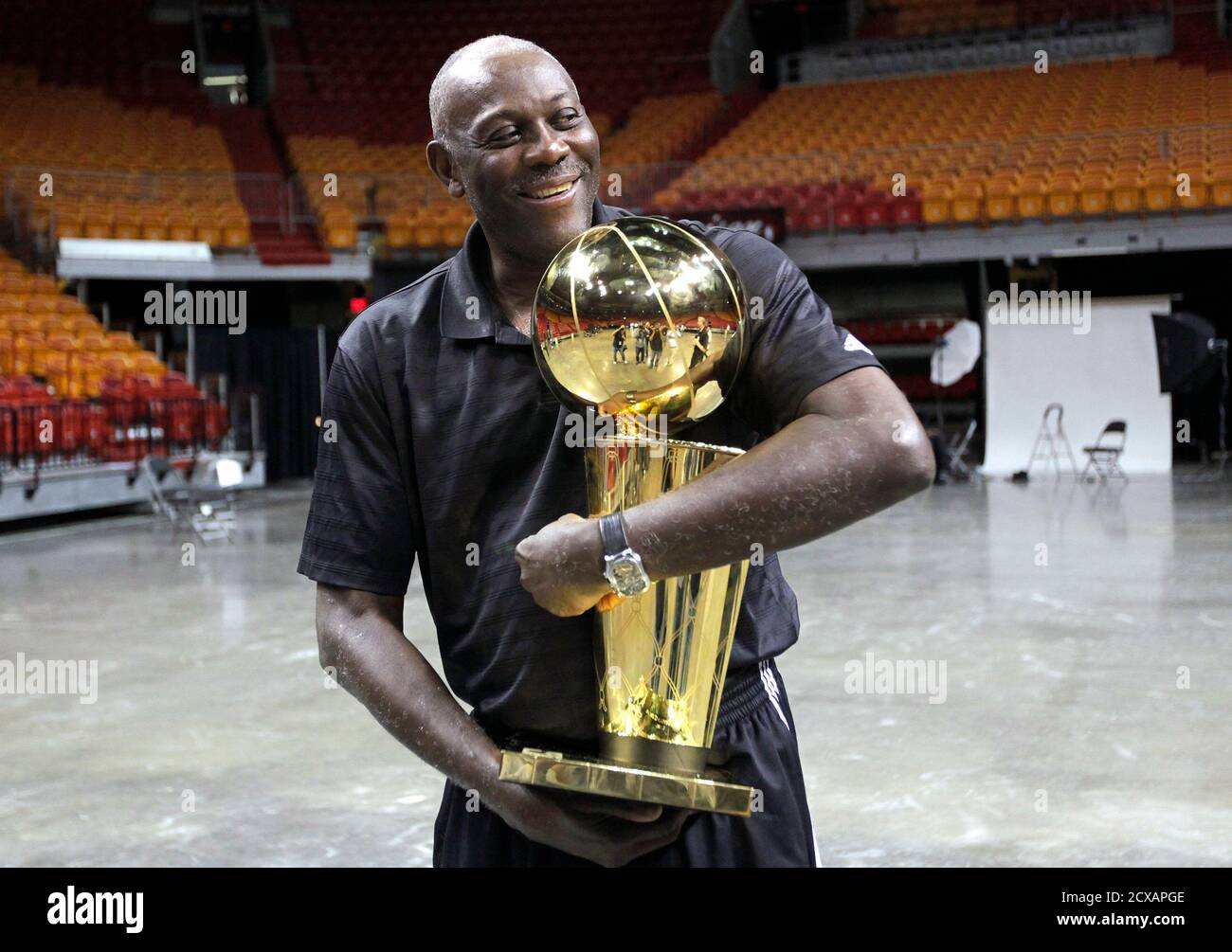 Heat Assistant Coach Bob McAdoo poses with the team's championship trophy  during media day at the Miami Heat's home arena in Miami, Florida September  28, 2012. REUTERS/Andrew Innerarity (UNITED STATES - Tags: