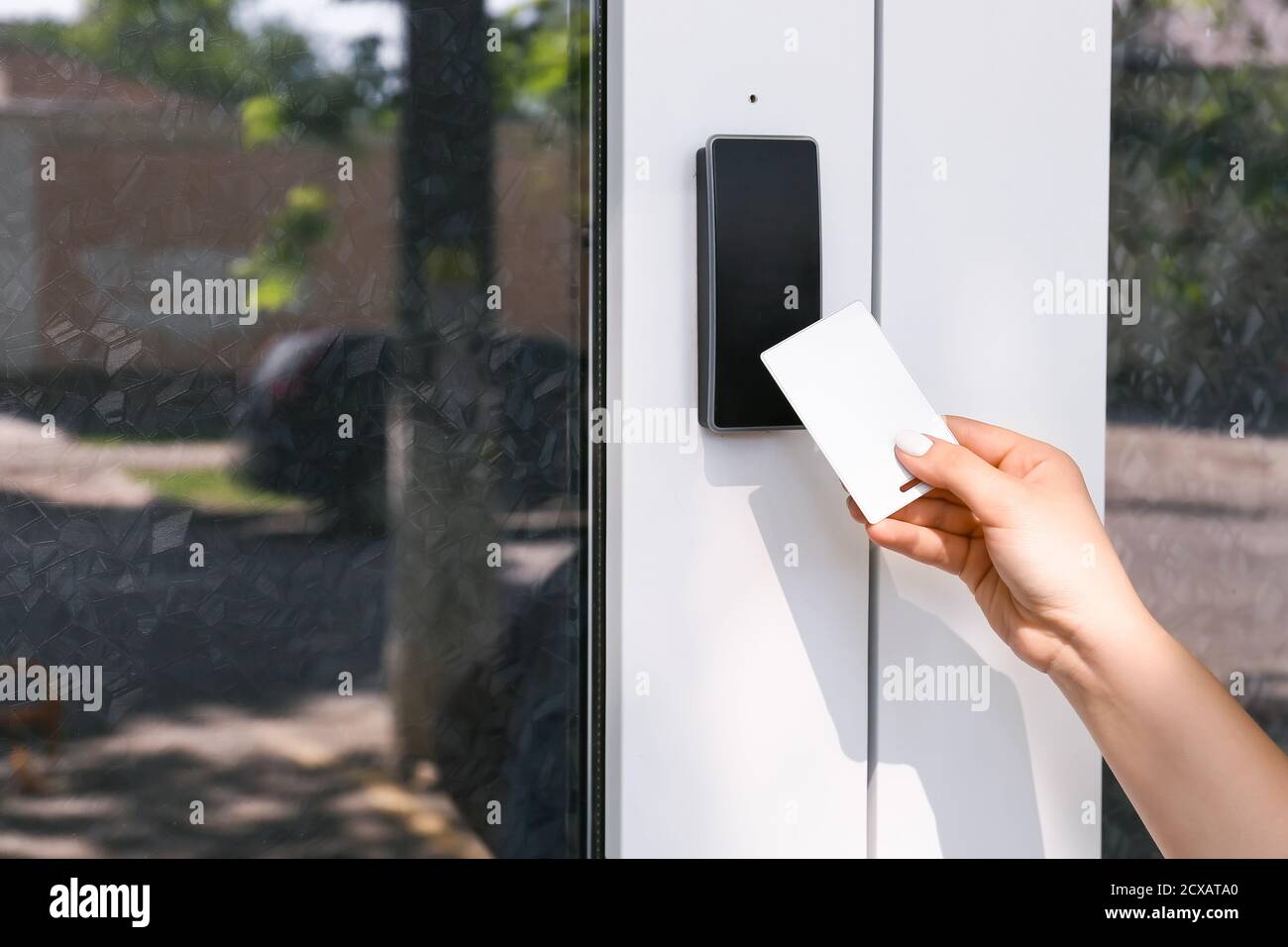 Woman using card to open door outdoors Stock Photo Alamy