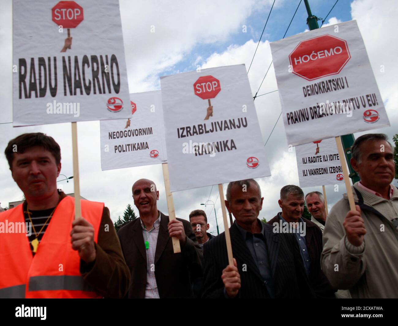 Workers with placards protest in Sarajevo May 30, 2013. Thousands of workers took to the streets in the Bosnian capital on Thursday to request more rights in the first mass protest in years in the impoverished Balkan country. Some 5,000 people from the Federation of Bosnian Muslims and Croats, which together with the Serb republic makes up Bosnia, took part in the peaceful protests staged by trade unions in a sign that their patience was running thin. Placards read,  'Stop Illegal work' (L), and 'Stop the explotation of workers' (2nd R).    REUTERS/Dado Ruvic (BOSNIA AND HERZEGOVINA - Tags: BU Stock Photo