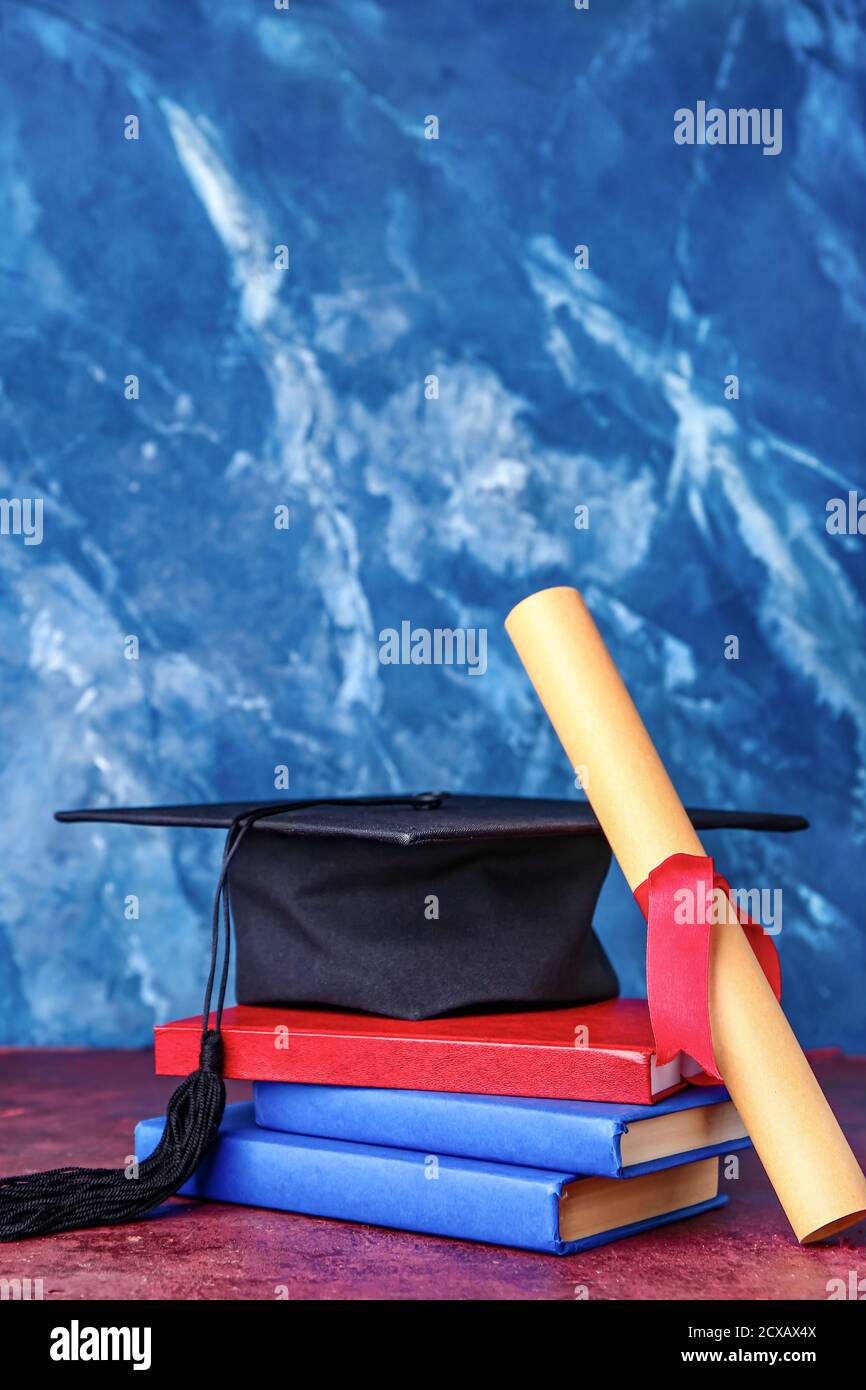 Graduation hat, diploma and books on color background Stock Photo - Alamy
