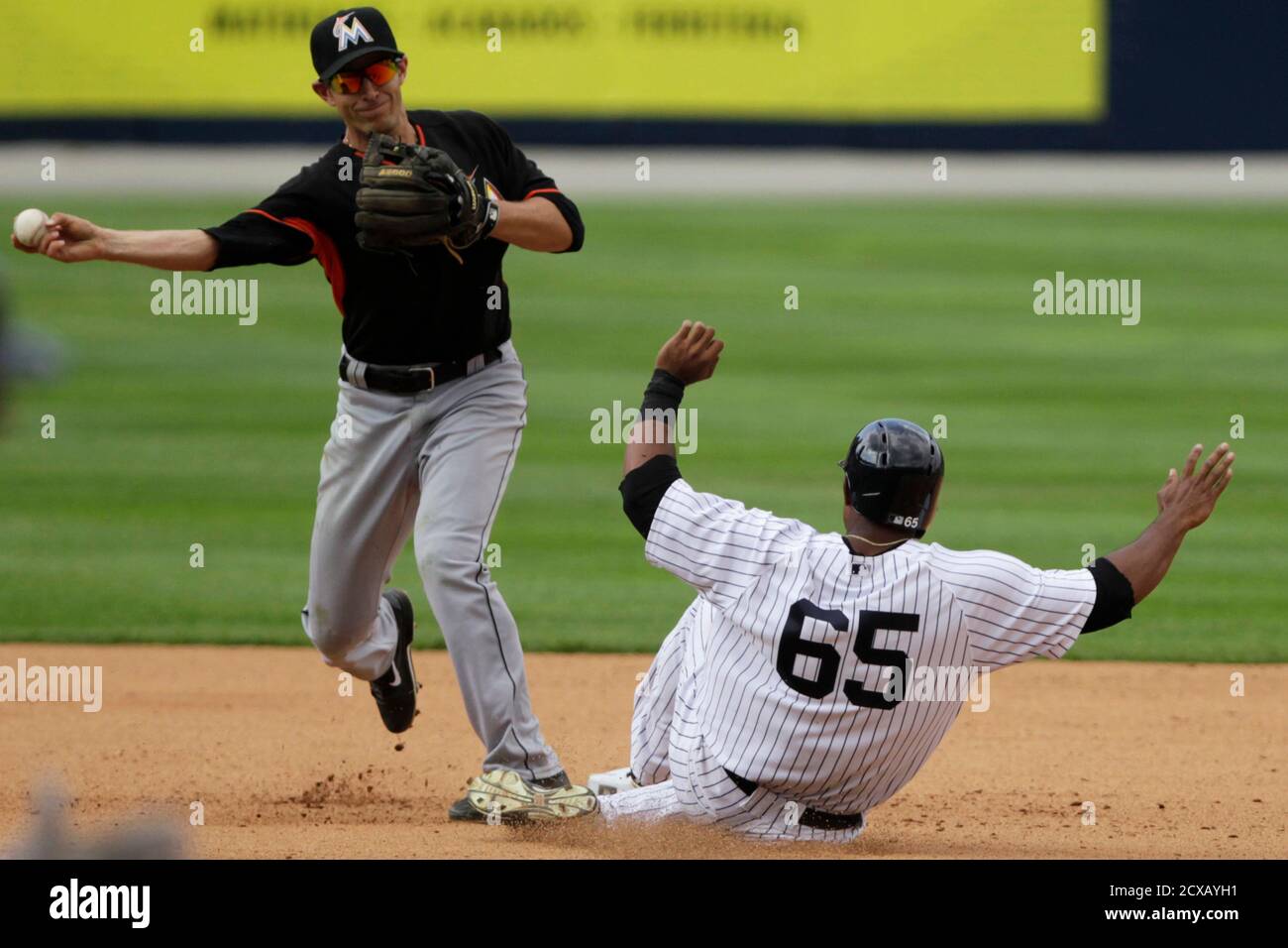 New York Yankees' Zoilo Almonte (R) is out at second base as Miami Marlins' Austin Nola tags on time during the seventh inning of the exhibition game 'Legend Series' honoring former Miami Marlins player Mariano Rivera, at the Rod Carew Stadium in Panama City March 16, 2014. Major League Baseball and the New York Yankees returned to Panama for the first time in 67 years on Saturday, offering one final goodbye to Mariano Rivera and bringing the career of the game's greatest closer full circle. REUTERS/ Carlos Jasso(PANAMA - Tags: SPORT BASEBALL) Stock Photo