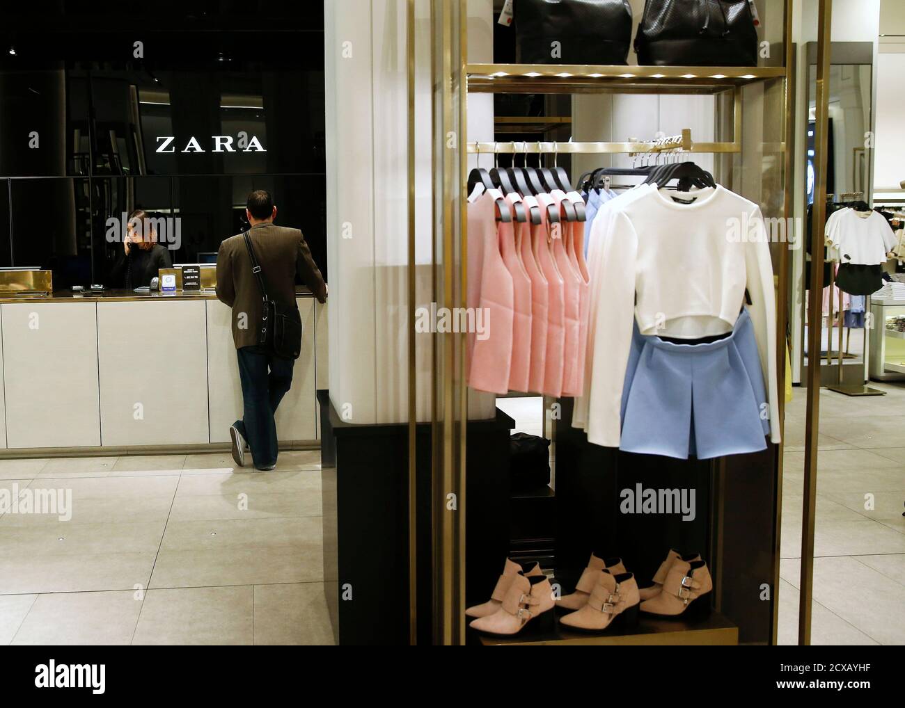 A man pays at a Zara store in central Madrid March 18, 2014. Inditex, the  world's biggest fashion retailer, will accelerate investment in 2014 to open  more new stores after results last