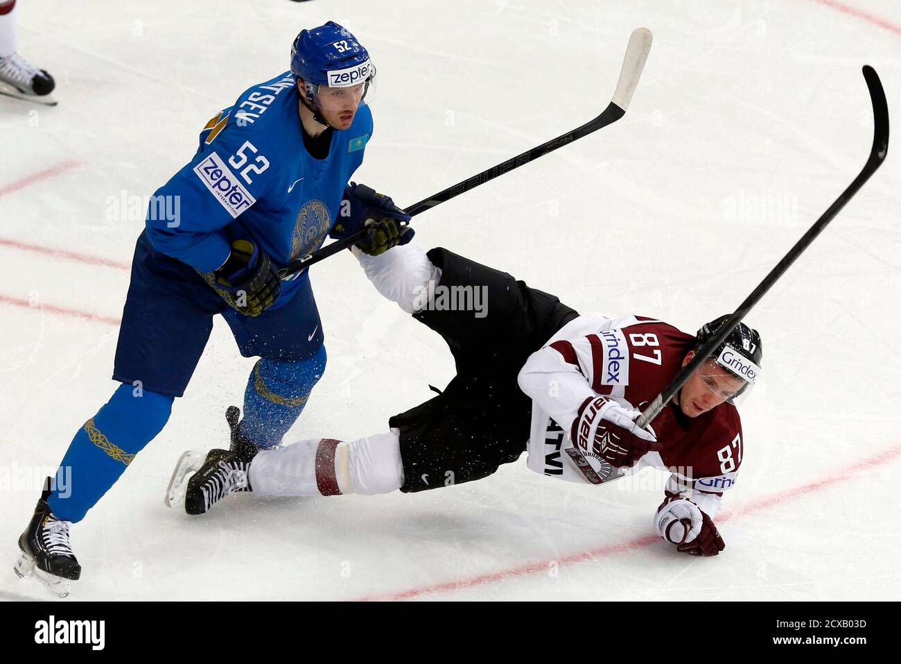 Latvia's Gints Meija (R) falls to the ice in front of Kazakhstan's Anton  Kazantsev (L) during