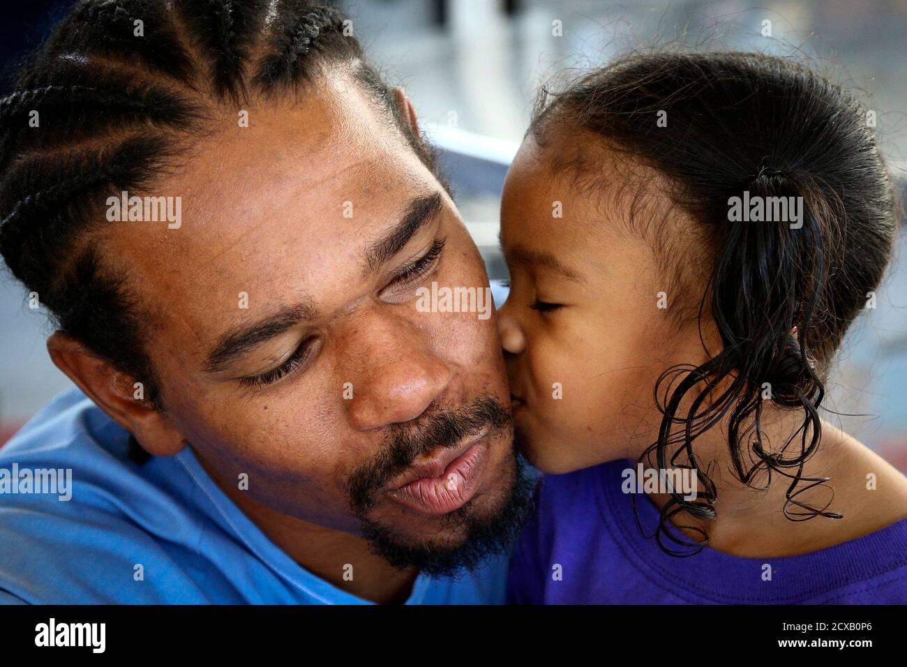 Pharaoh Haywood receives a kiss from his daughter Isis, 2, of Sacramento,  during a "Get On the Bus" visiting day to Folsom State Prison arranged by  the California Department of Corrections and