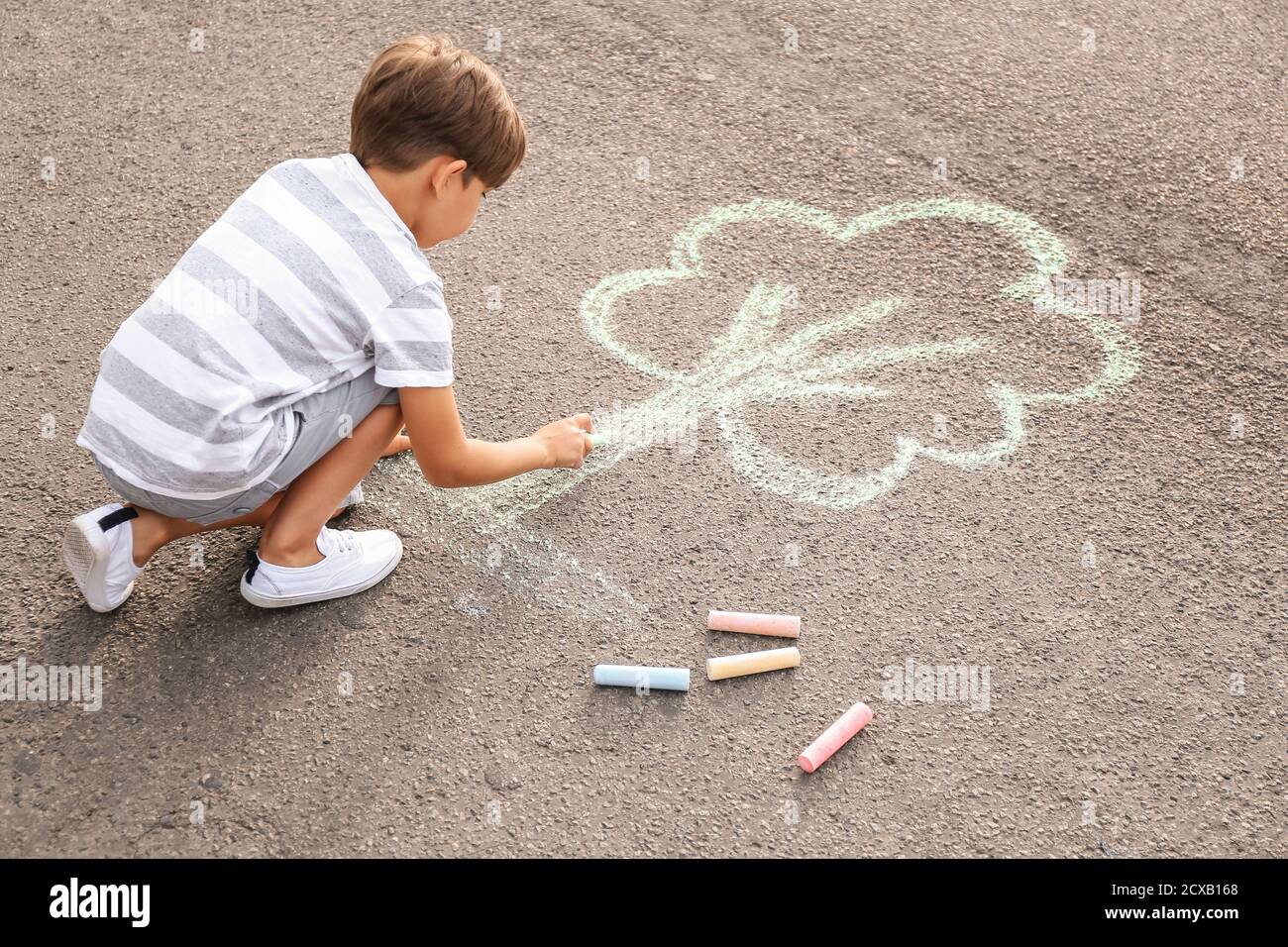 Little boy drawing tree with chalk on asphalt Stock Photo - Alamy