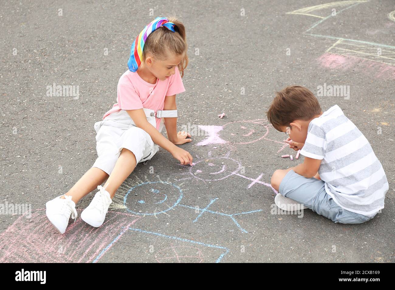 Little children drawing with chalk on asphalt Stock Photo - Alamy
