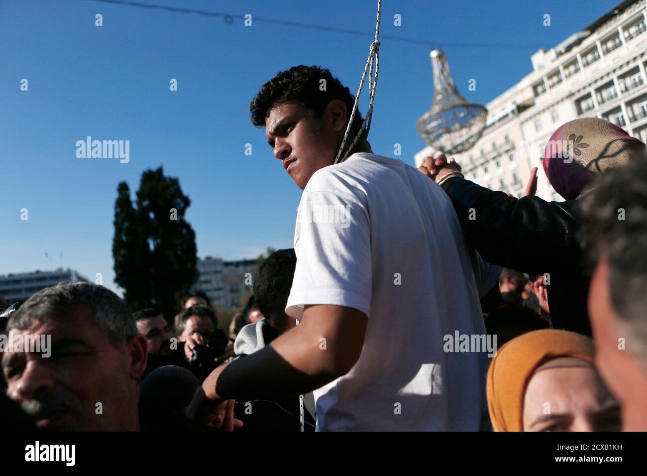 A Syrian refugee with a noose around his neck protests at the main Syntagma square in Athens December 14, 2014. Greece's government has said it could do little to help about 300 Syrian refugees camped outside parliament for weeks because none of them had applied for asylum or shelter. The Syrian refugees, including women and children, have defied the rain and cold to sleep on the pavement opposite parliament since November 19, demanding the right of passage to other European countries to be reunited with family members.  REUTERS/Alkis Konstantinidis (GREECE - Tags: POLITICS SOCIETY IMMIGRATION Stock Photo